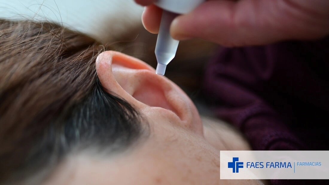 Mujer echándose gotas en los oídos, una forma farmacéutica líquida habitual en la farmacia.