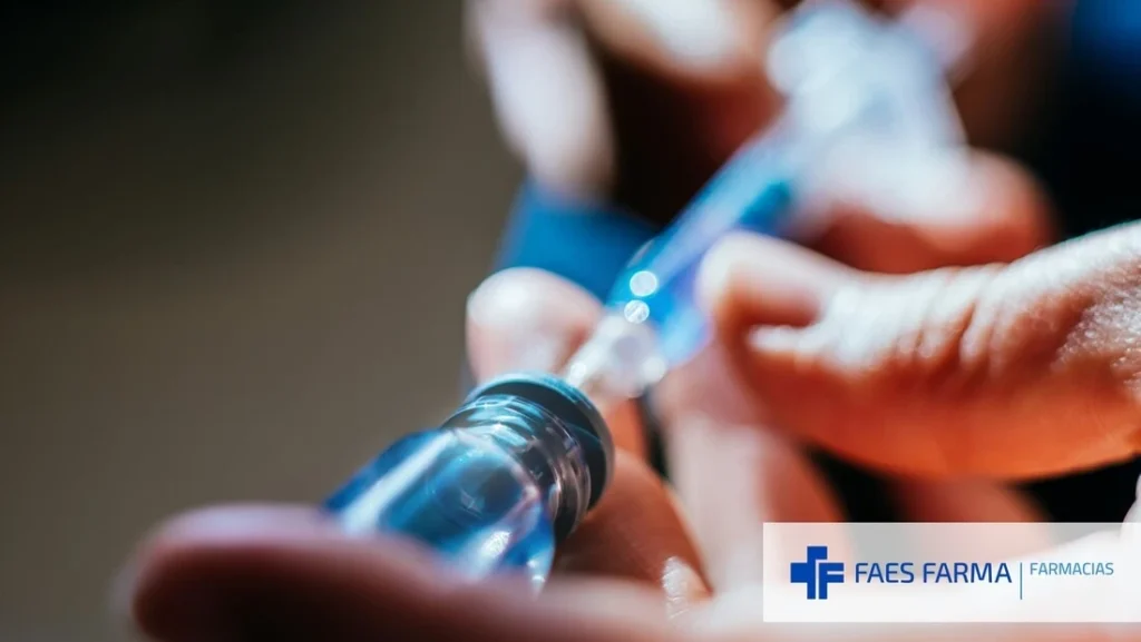 Profesional sanitario extrayendo contenido de un vial que contiene una forma farmacéutica líquida.